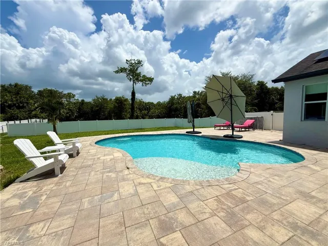 View of swimming pool with a patio area and a fenced backyard