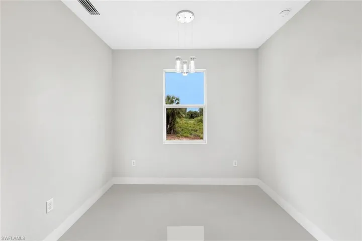 Unfurnished room with an inviting chandelier and concrete floors