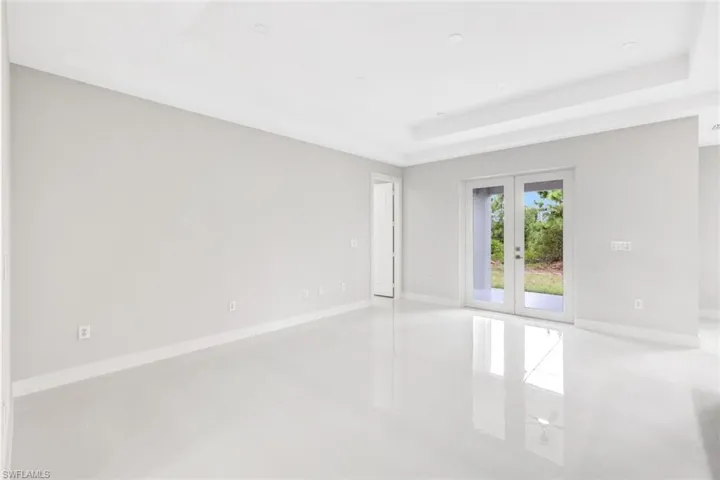 Unfurnished room featuring a raised ceiling, tile patterned flooring, and french doors