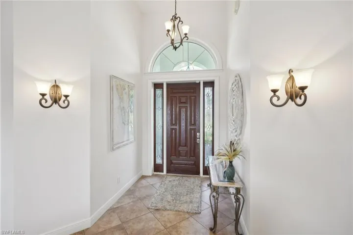 Entryway featuring a chandelier, light tile patterned flooring, and a towering ceiling