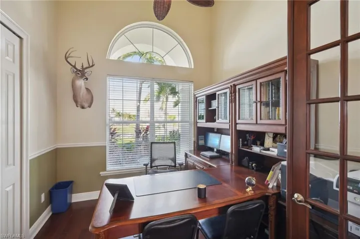 Office featuring dark wood-type flooring and ceiling fan