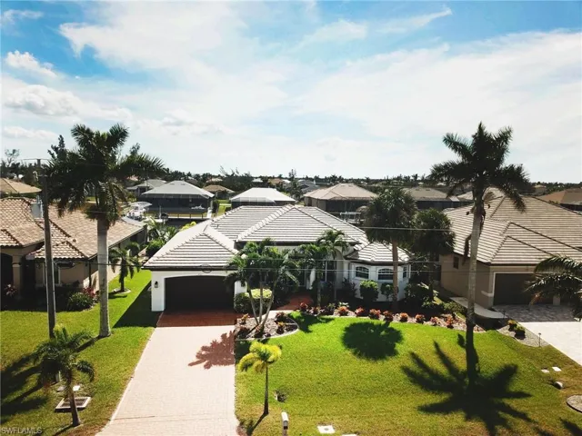 View of front of house with a garage and a front lawn