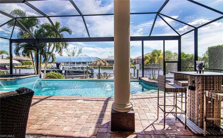 View of pool with an in ground hot tub, pool water feature, and water view