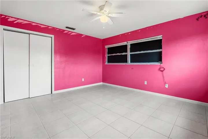 Unfurnished bedroom featuring ceiling fan, a closet, and light tile flooring