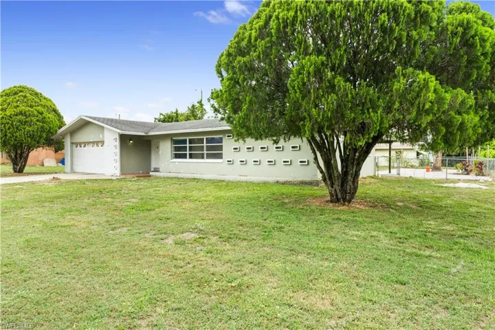 View of front of home featuring a garage and a front yard
