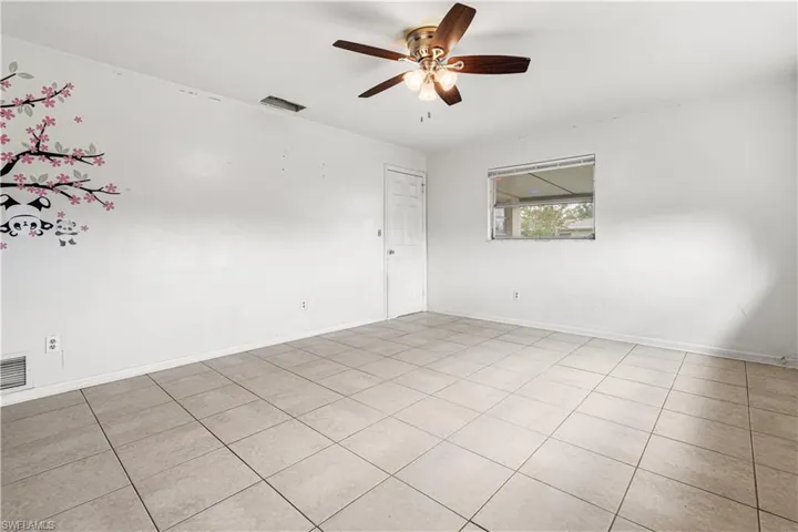 Spare room featuring ceiling fan and light tile floors