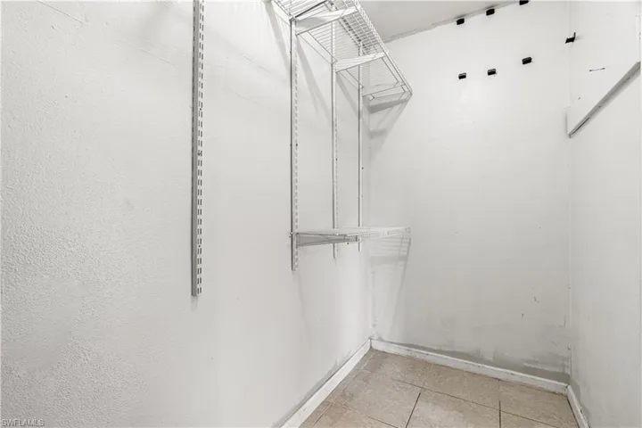 Walk in closet with light tile floors
