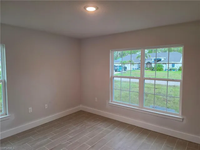 Room featuring light neutral wall tones and wood-finish tile flooring