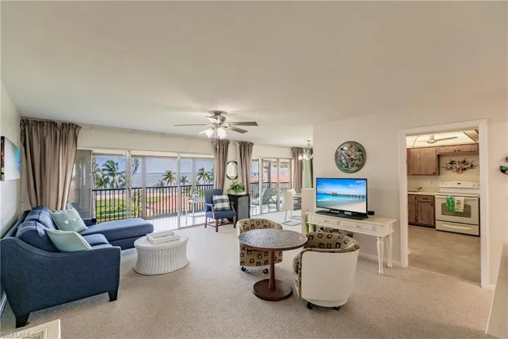 Carpeted living room with ceiling fan