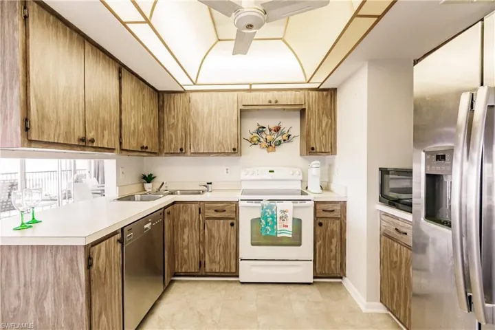 Kitchen featuring ceiling fan, light tile patterned floors, stainless steel appliances, and sink