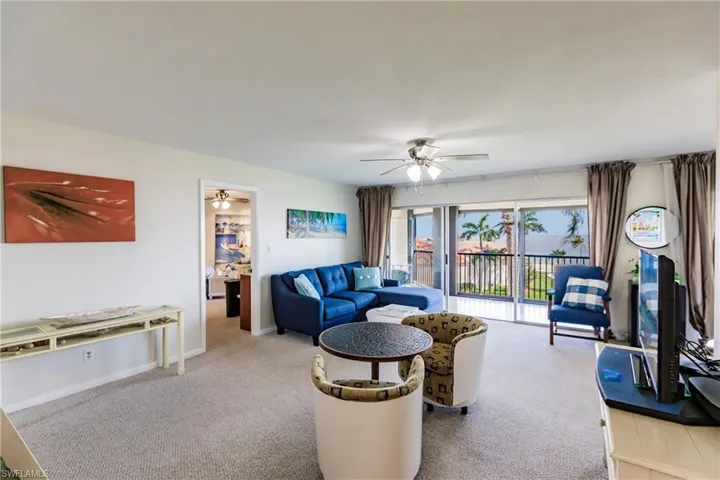 Carpeted living room with ceiling fan