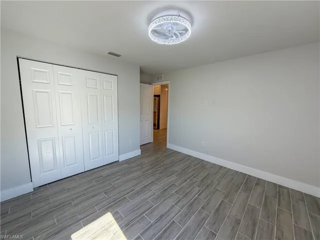 Unfurnished bedroom featuring a closet and wood tiled floors