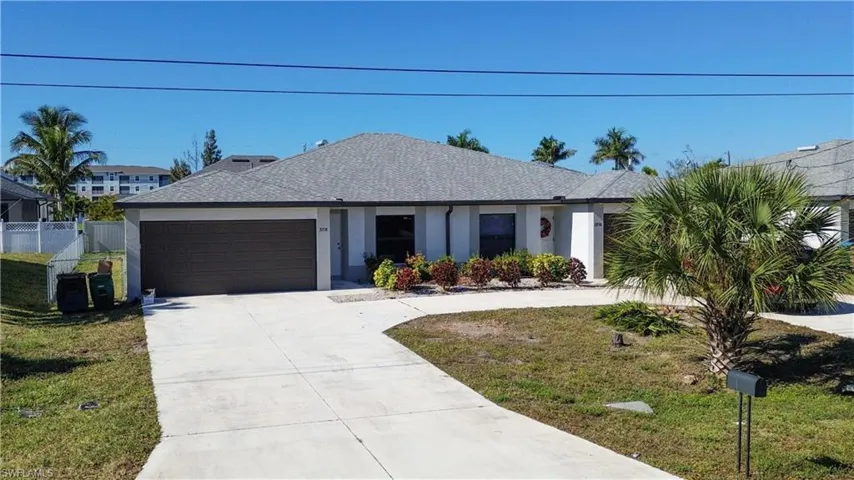 Ranch-style house with driveway, roof with shingles, stucco siding, and an attached garage