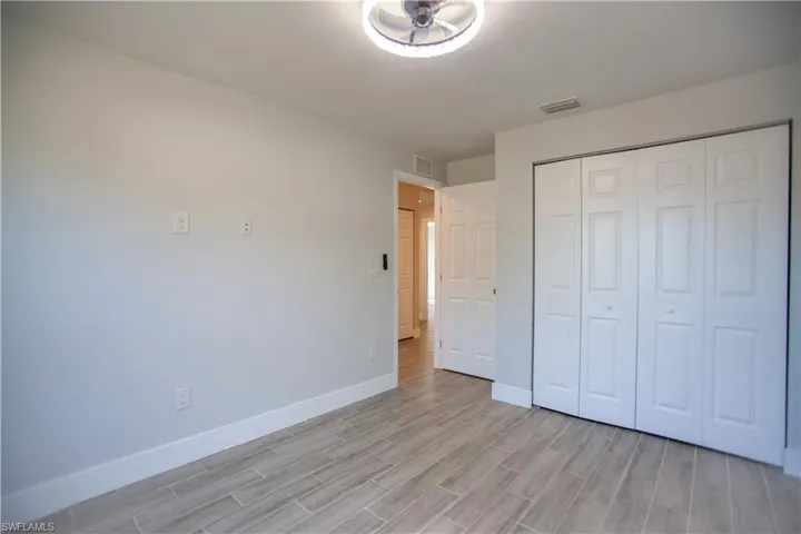 Unfurnished bedroom with wood tiled floors and a closet