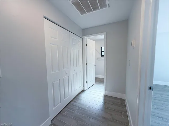 Corridor featuring baseboards and wood finish floors