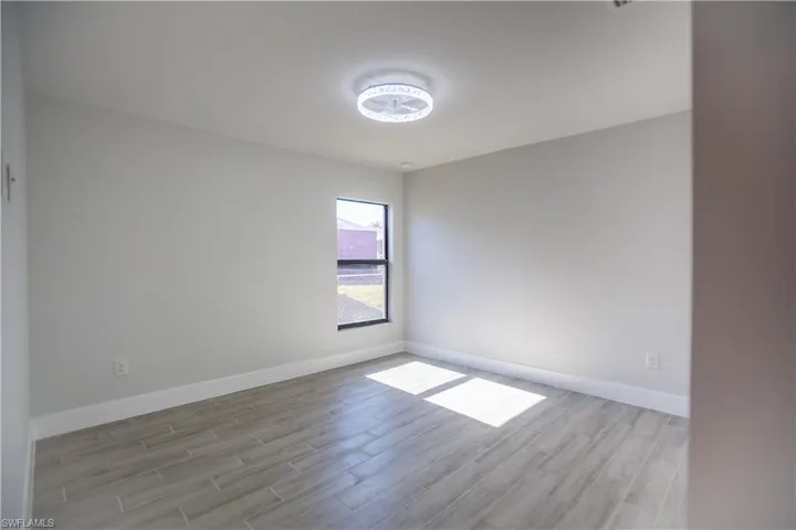 Spare room featuring wood tiled floors and baseboards