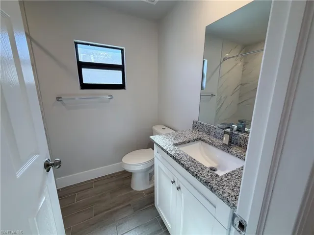 Bathroom featuring vanity, wood tiled floors, and a shower