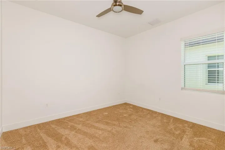 Carpeted bedroom featuring ceiling fan
