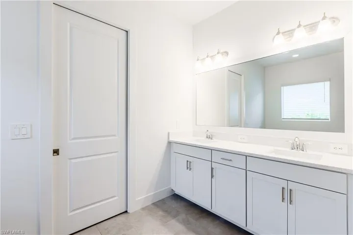 Bathroom featuring tile patterned flooring and dual bowl vanity
