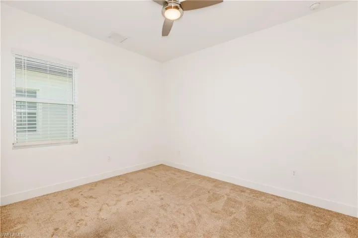 Carpeted bedroom with ceiling fan