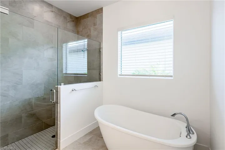 Bathroom with independent shower and bath and tile patterned floors