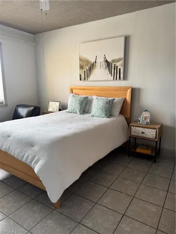 Tiled bedroom featuring a textured ceiling