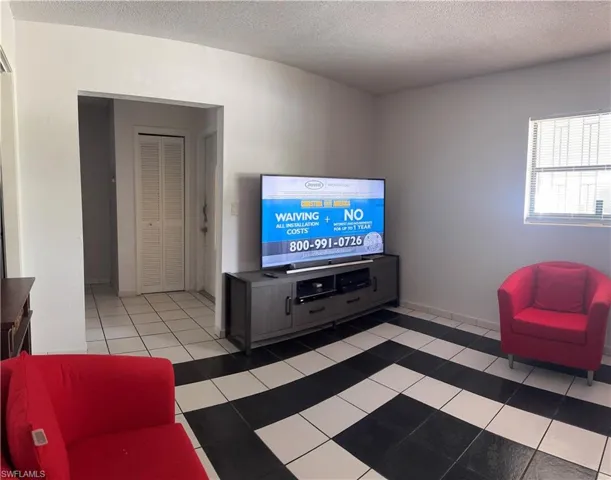 Living room with tile patterned flooring and a textured ceiling