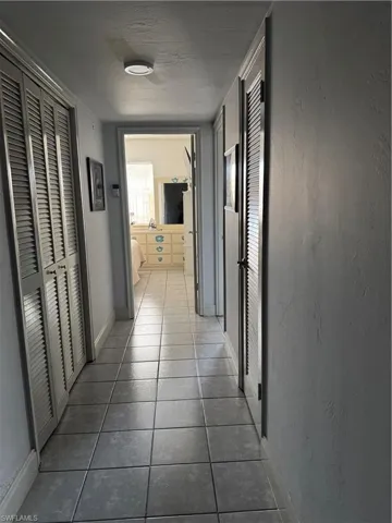 Hallway featuring tile patterned flooring and baseboards