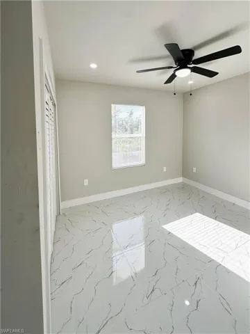 Tiled empty room featuring ceiling fan