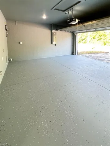 Garage with electric panel and a garage door opener