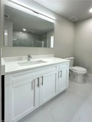 Bathroom with tile patterned floors, vanity, and toilet