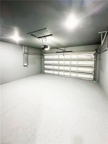 Garage featuring a garage door opener and electric panel