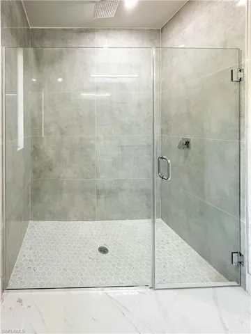 Bathroom featuring tile patterned floors and a shower with door