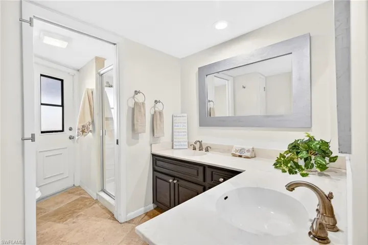 Bathroom with double vanity and a stall shower