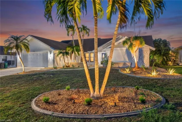 View of front of home featuring driveway, a front yard, a garage, and stucco siding