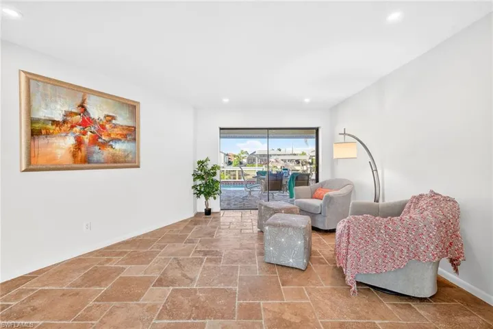 Entrance to foyer looking into the Sitting room featuring stone tile floors and recessed lighting