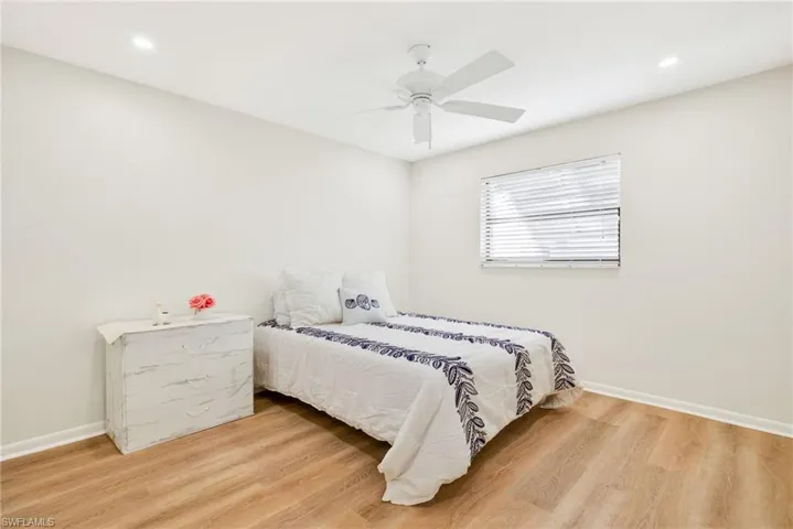 Bedroom with light wood finished floors, a ceiling fan, and recessed lighting