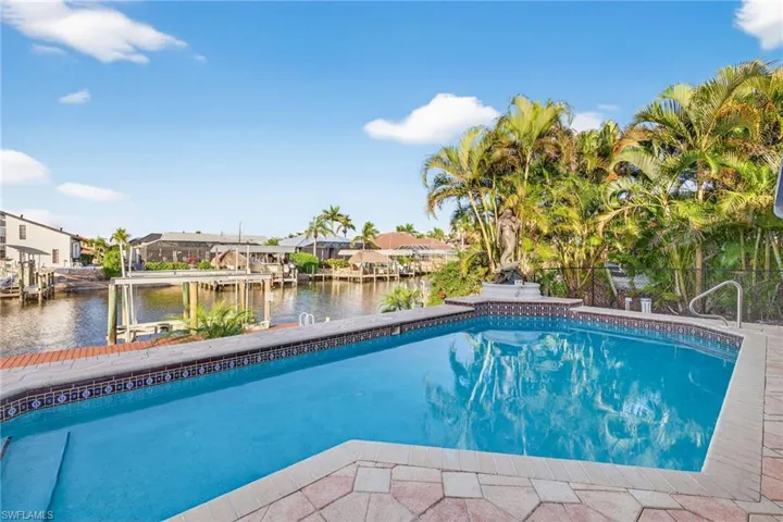 Swimming pool featuring a water view, a residential view, boat lift, and a boat dock