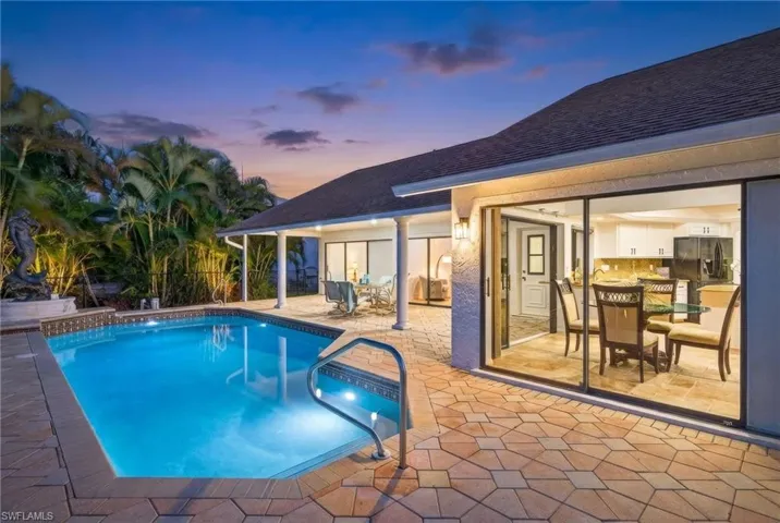 Pool at dusk with a patio and an outdoor pool