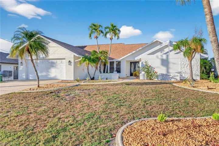 Single story home with concrete driveway, a front lawn, an attached garage, stucco siding, and a shingled roof