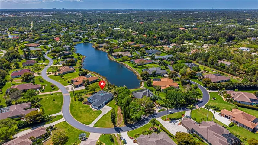 Aerial view of property and surrounding area featuring a large body of water and nearby suburban area