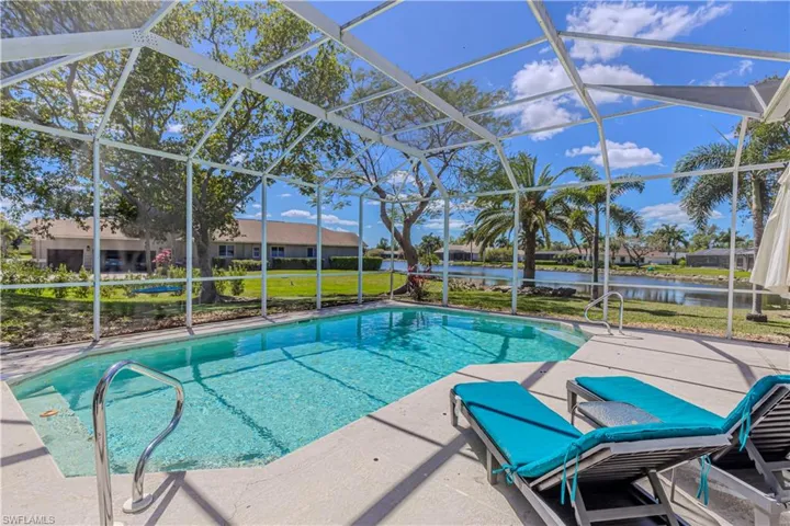 Swimming pool featuring screen enclosure, patio area, & lake view