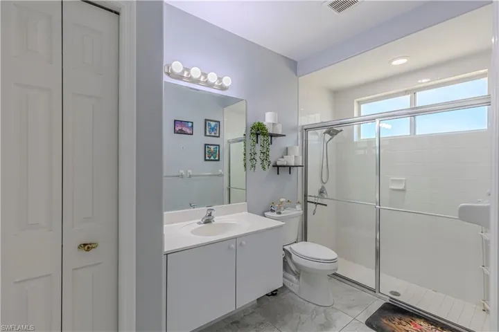 Guest Bathroom featuring vanity, shower stall, closet, & recessed lighting