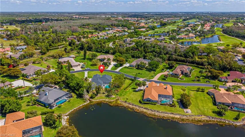 Aerial view of property and surrounding area featuring a nearby body of water and nearby suburban area