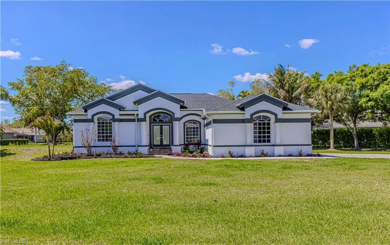View of front facade with stucco siding and a front lawn