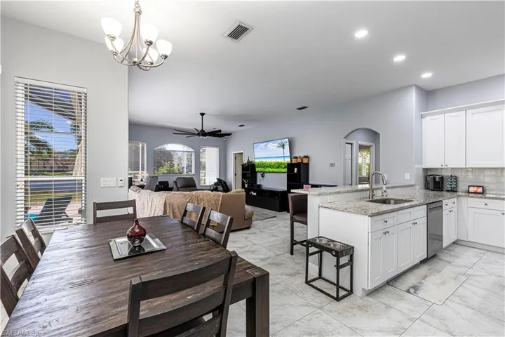 Dining room with ceiling fan, arched walkways, plenty of natural light, and hanging lights