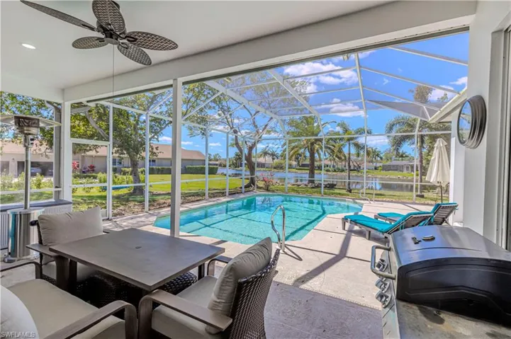 Outdoor pool featuring a patio, outdoor dining area, screen enclosure & lake view
