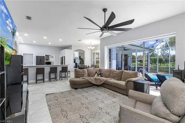 Family room w/ access to pool, kitchen bar & lake view