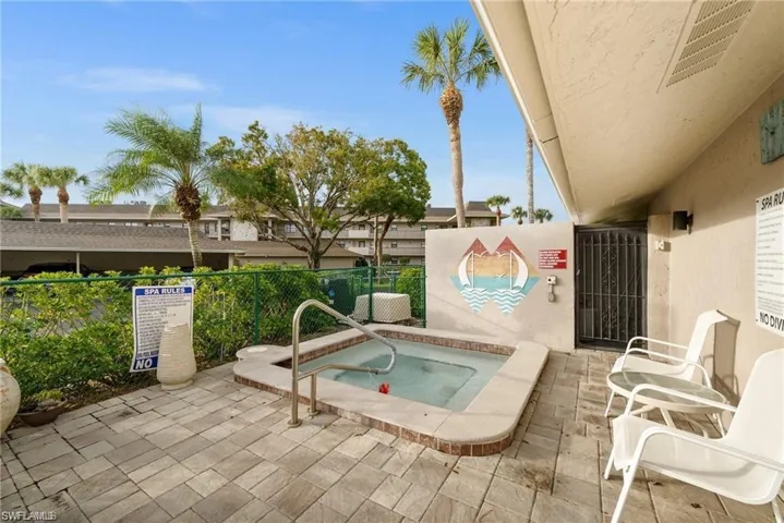 View of swimming pool with a community hot tub and a patio