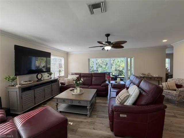 Living area featuring ornamental molding, wood finished floors, a ceiling fan, and recessed lighting